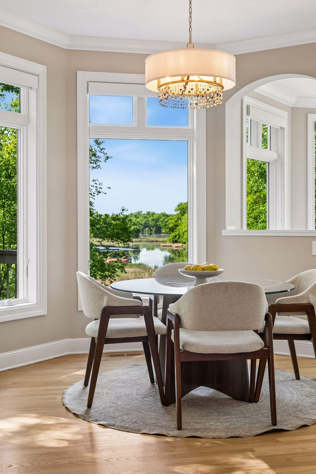 Lovely dinette surrounded by windows, offering beautiful natural light and picturesque lake views.
