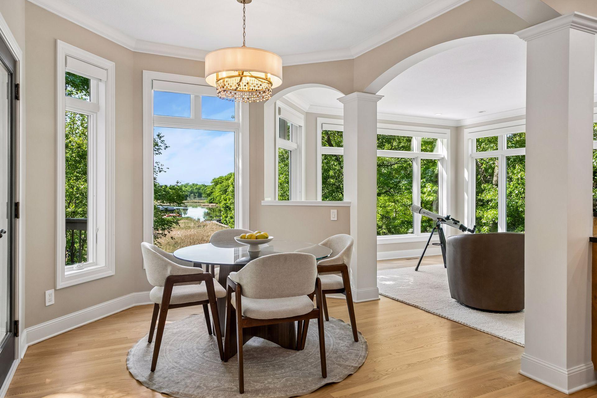 Lovely dinette surrounded by windows, offering beautiful natural light and picturesque lake views.