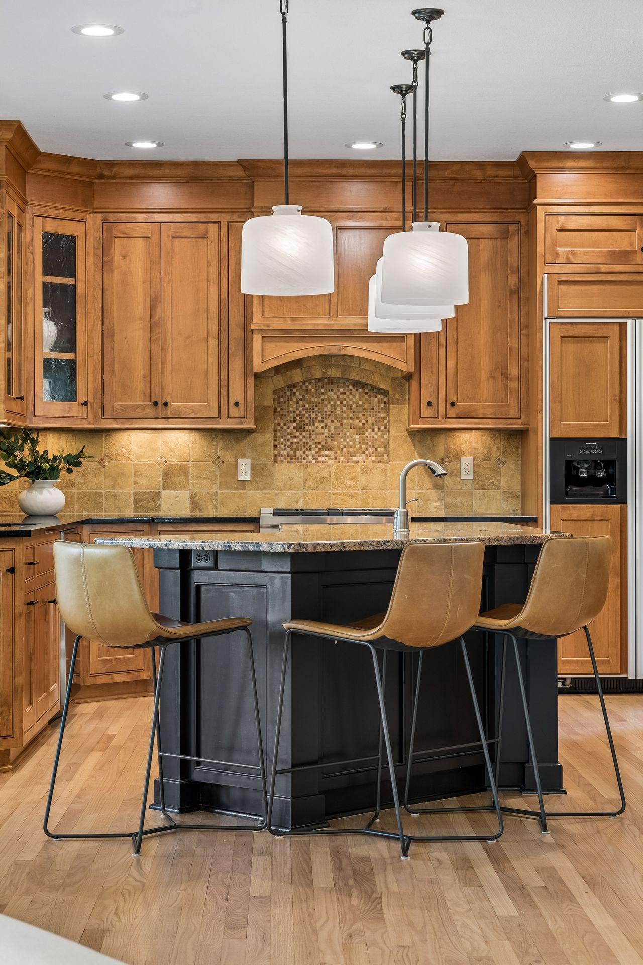The heart of the home, this spotless kitchen features Wolf appliances, newly refinished granite countertops, beautifully refinished hardwood floors, and cabinets galore.