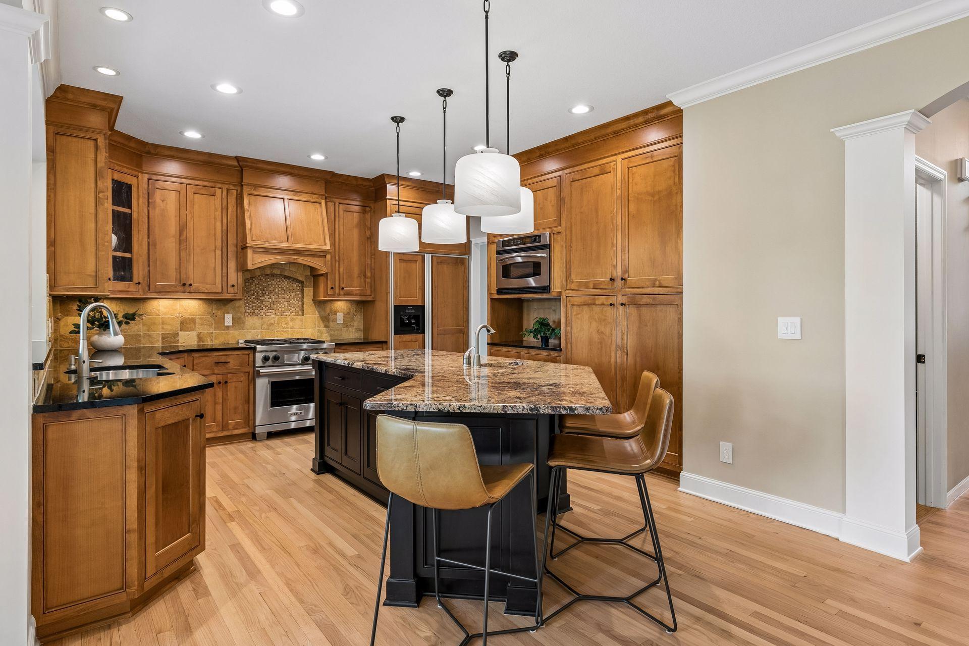 The heart of the home, this spotless kitchen features Wolf appliances, newly refinished granite countertops, beautifully refinished hardwood floors, and cabinets galore.