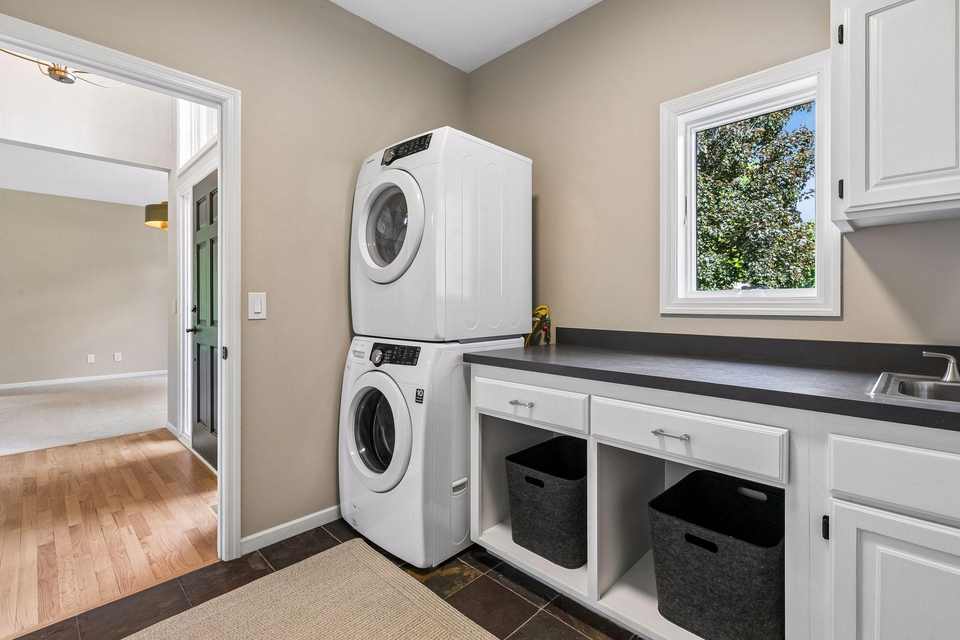 The tiled mudroom and laundry room make everyday living easy. Just beyond, you'll find an oversized three-stall garage with newly finished floors and a finished shop ready for hobbies, projects, or extra storage.