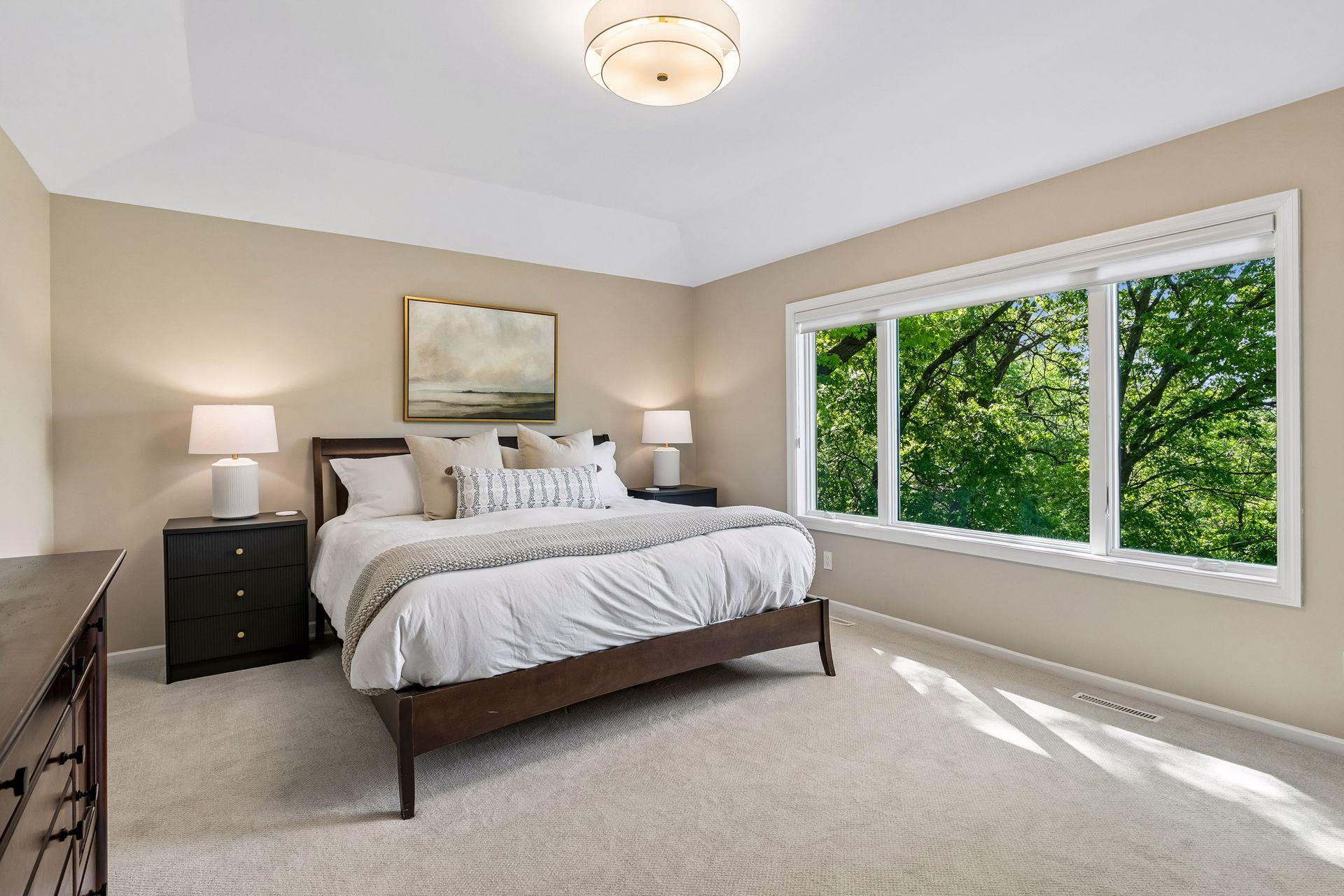 This primary suite is exceptional, featuring a spacious bedroom, a cozy reading nook, and a warm, spa-like bath with a separate tub and shower. Step out onto the private maintenance-free balcony and take in sweeping views of the 1+ acre lot and Lake