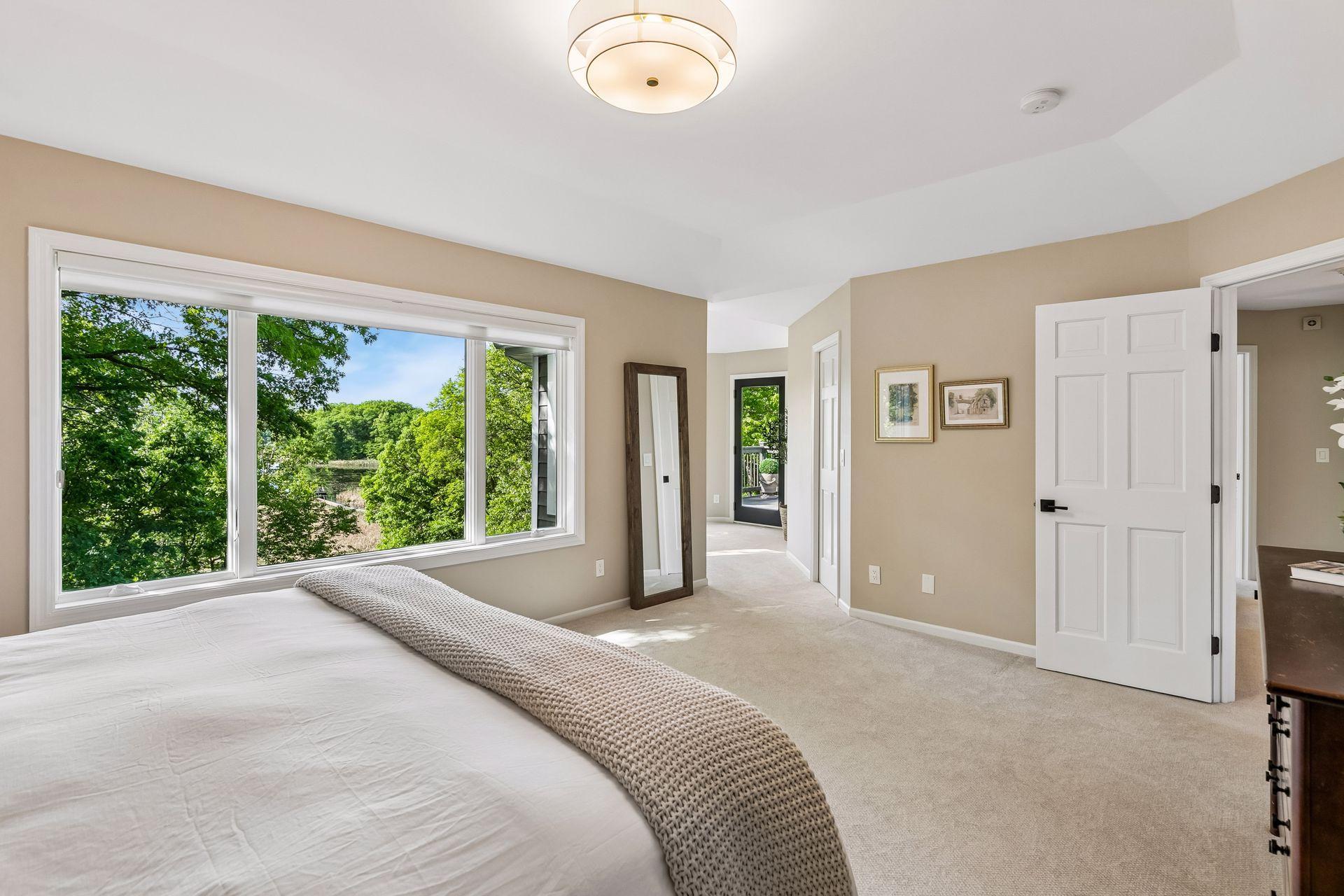 This primary suite is exceptional, featuring a spacious bedroom, a cozy reading nook, and a warm, spa-like bath with a separate tub and shower. Step out onto the private maintenance-free balcony and take in sweeping views of the 1+ acre lot and Lake