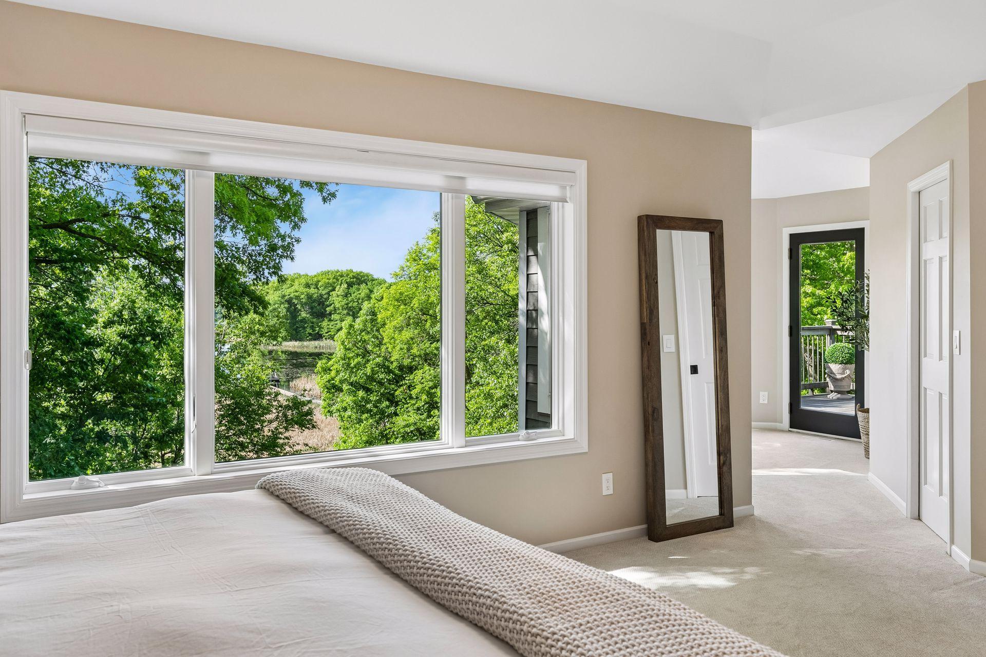 This primary suite is exceptional, featuring a spacious bedroom, a cozy reading nook, and a warm, spa-like bath with a separate tub and shower. Step out onto the private maintenance-free balcony and take in sweeping views of the 1+ acre lot and Lake