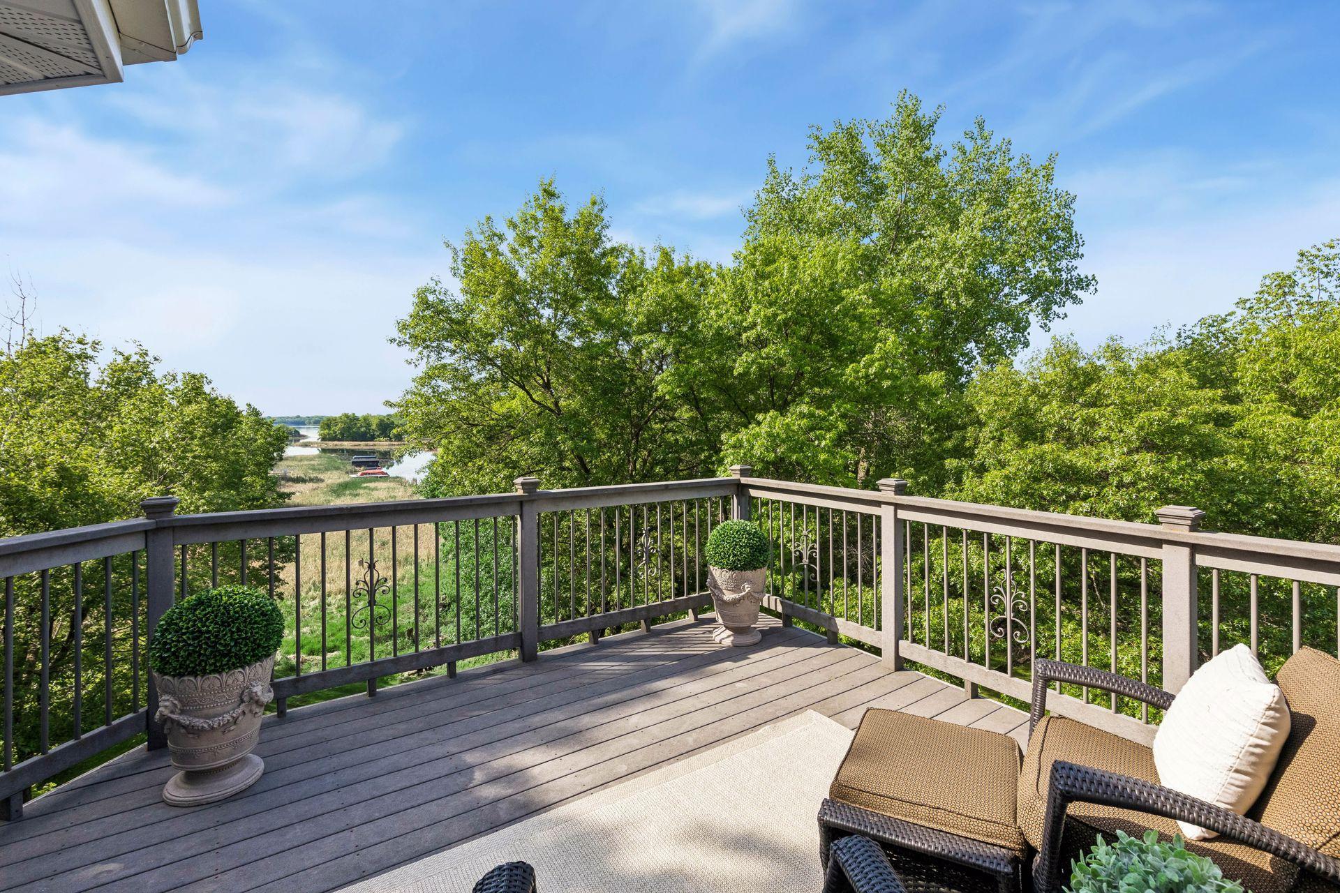 This primary suite is exceptional, featuring a spacious bedroom, a cozy reading nook, and a warm, spa-like bath with a separate tub and shower. Step out onto the private maintenance-free balcony and take in sweeping views of the 1+ acre lot and Lake