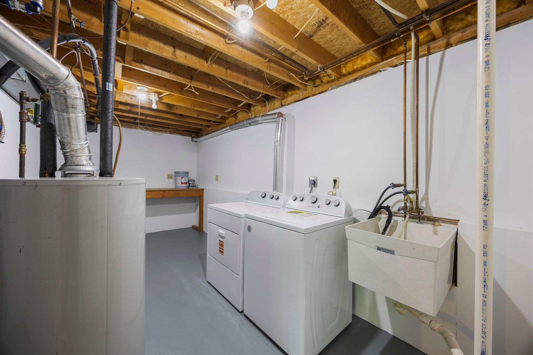 The large, clean laundry and utility room features a new washer and dryer (2025) along with plenty of additional storage space.