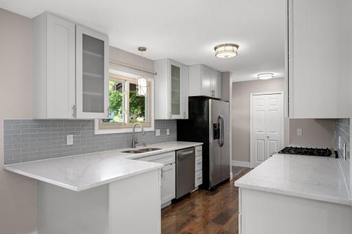 Just off the entry is the incredible cook's kitchen! Enjoy stainless steel appliances - a gas stove (!), updated overhead/pendant lighting and even a kitchen window overlooking the front yard!
