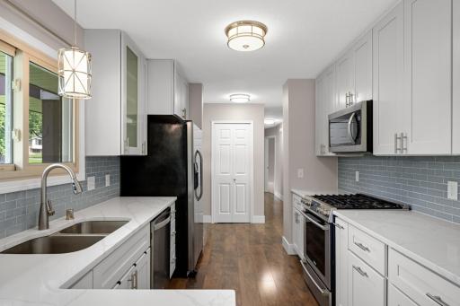 Another view of the kitchen showcases the large amount of cabinets and counter space! Both cabinets and drawers are soft close and don't miss the beautiful backsplash.