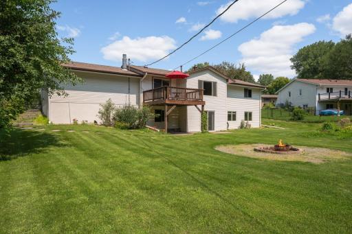 The back of the house featuring a nice flat lot with firepit, gardens and tons of room for play.