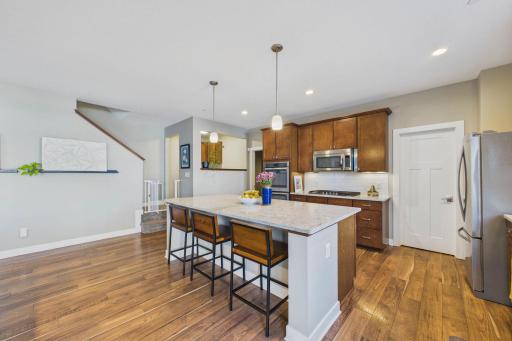 The quartz island is perfect for a quick meal of breakfast! To the right and ahead is a pantry with custom shelving.