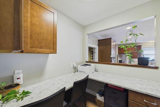 This bonus study area/planning center near the kitchen is ideal for day-to-day tasks. This space offers visibility to the kitchen and features additional cabinetry space and quartz counters that match the kitchen!