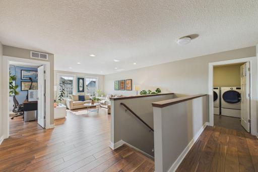 Step on up to the upper-level where you will be greeted with a spacious landing and sun-filled loft! The laundry area is also on this level. To the left is one of four bedrooms on this level.