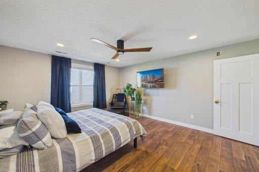 The recessed lighting along with a modern fan and flooring, add to the appeal to the space.