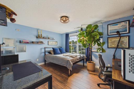 This is one of four bedrooms on this level. This room offers views of the front yard through the large windows and modern luxury vinyl plank flooring and an updated light fixture.