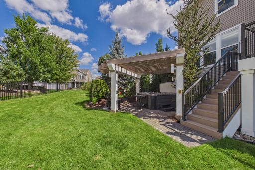 The pergola with accent lighting and patio add to the outdoor enjoyment all year round! The yard is also fully fenced with a wrought iron fencing system.
