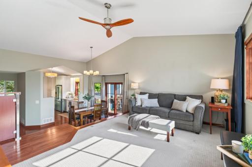 Sun-filled living room with vaulted ceiling, large windows and a spacious layout overlooking the surrounding neighborhood.