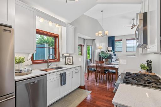Kitchen opens directly to the dining area, with hardwood floors, vaulted ceilings and plenty of natural light throughout.
