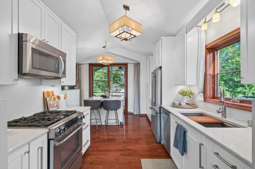 Another view of the kitchen highlighting the extensive cabinetry, stainless steel appliances, quartz countertops and center island seating.