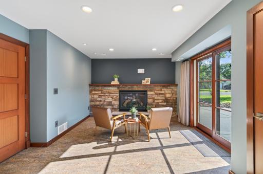 Inviting lower-level sitting area with stone fireplace and direct access to the outdoors.