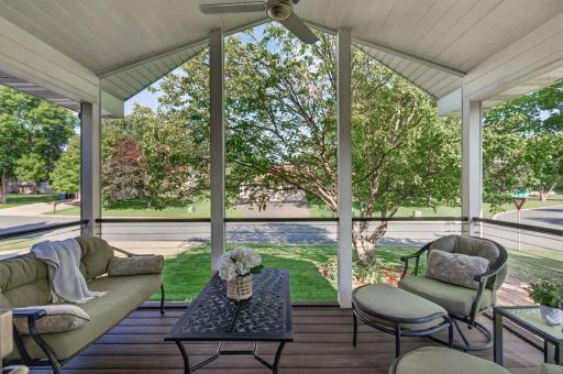 Vaulted screened porch with composite decking, ceiling fan and plenty of space for comfortable outdoor seating while enjoying the tree-lined surroundings.
