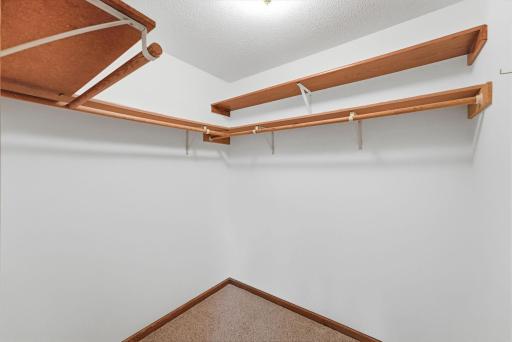 Walk in closet with built in shelving and hanger room.