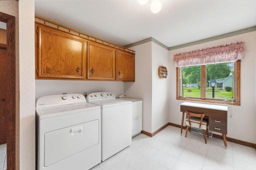 Well-appointed laundry space offers cabinetry, storage, and a sink for added convenience.