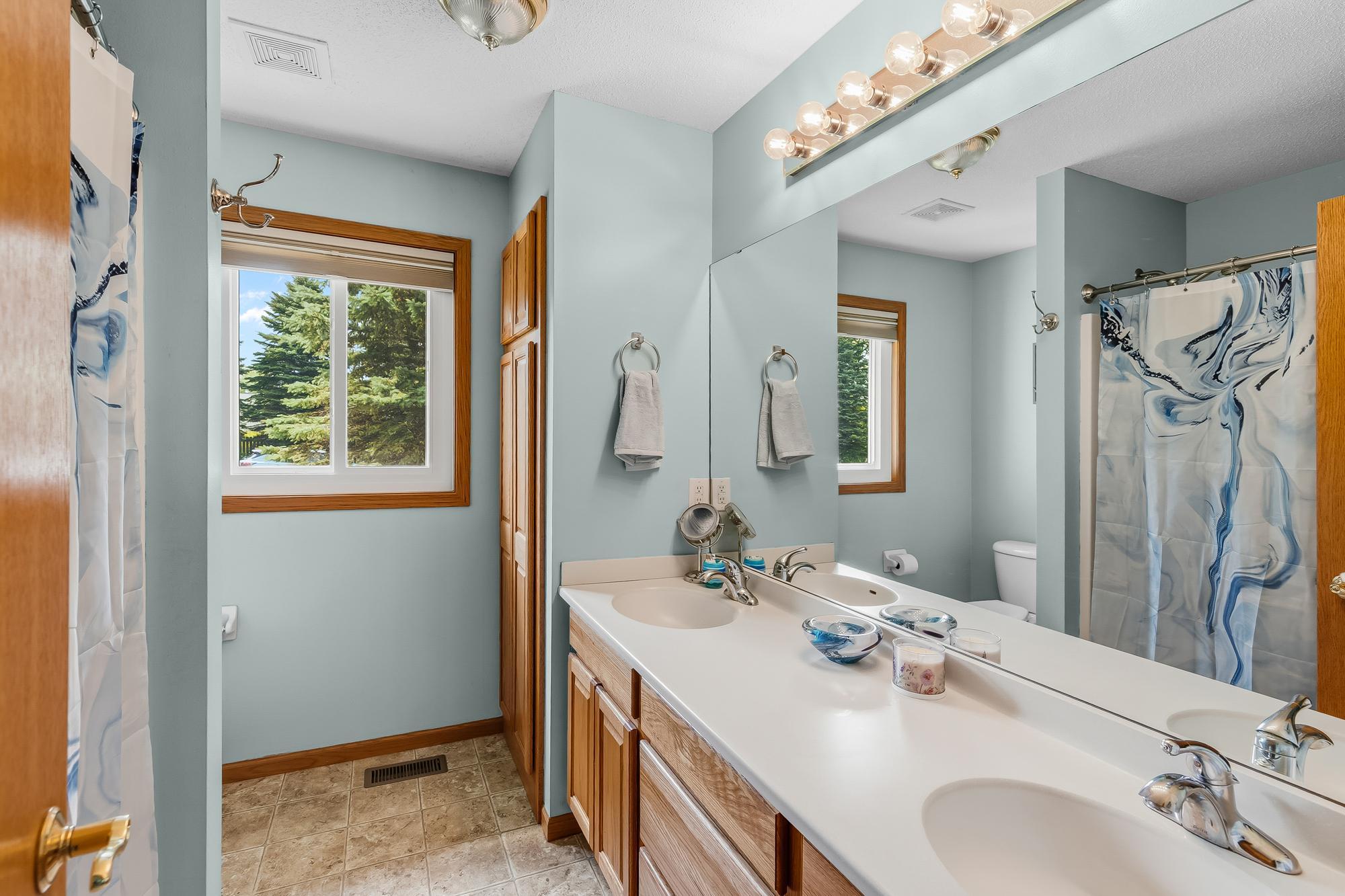 The full primary bathroom features a large double vanity and fantastic built-in linen storage.