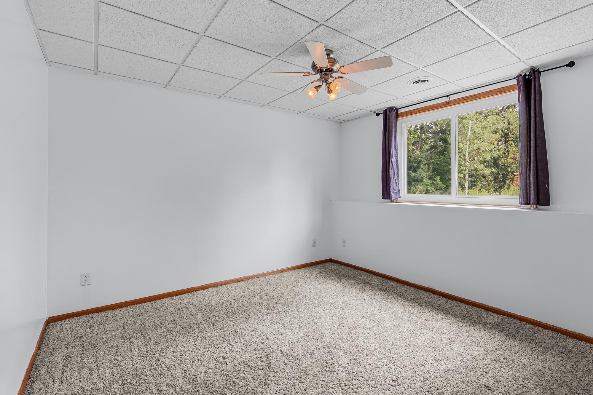 This is one of the two generously sized lower-level bedrooms, featuring great natural light through the lookout windows.