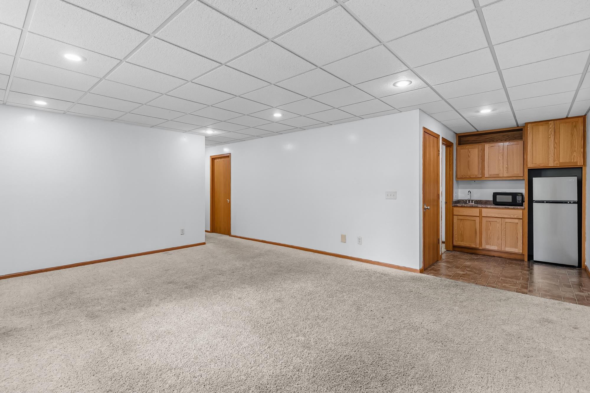 The finished lower-level family room features a fantastic wet bar that is perfect for entertaining.