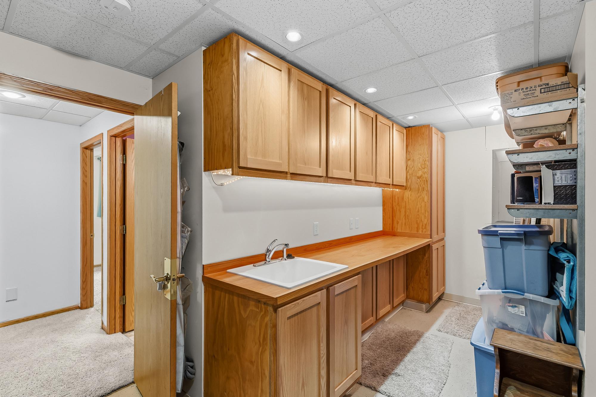 An expansive 11x8 lower-level utility room provides incredible additional storage, cabinetry, and workspace.