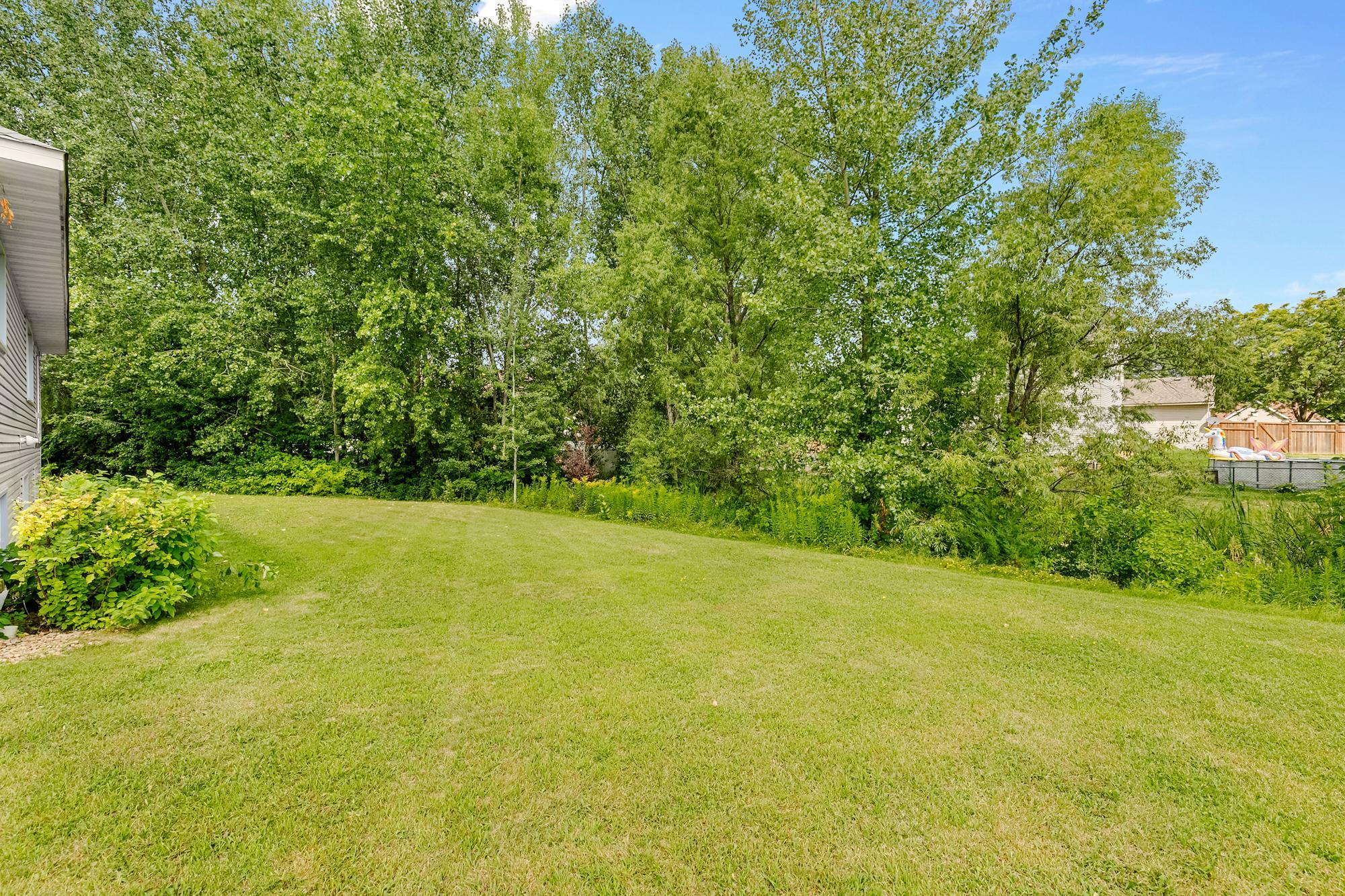 The sprawling backyard backs up to a pond