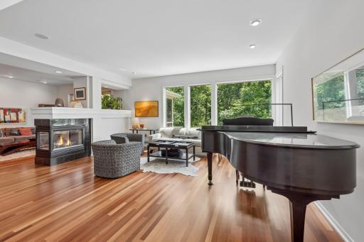 Living room with see-through gas fireplace, soaring ceilings, walls of windows