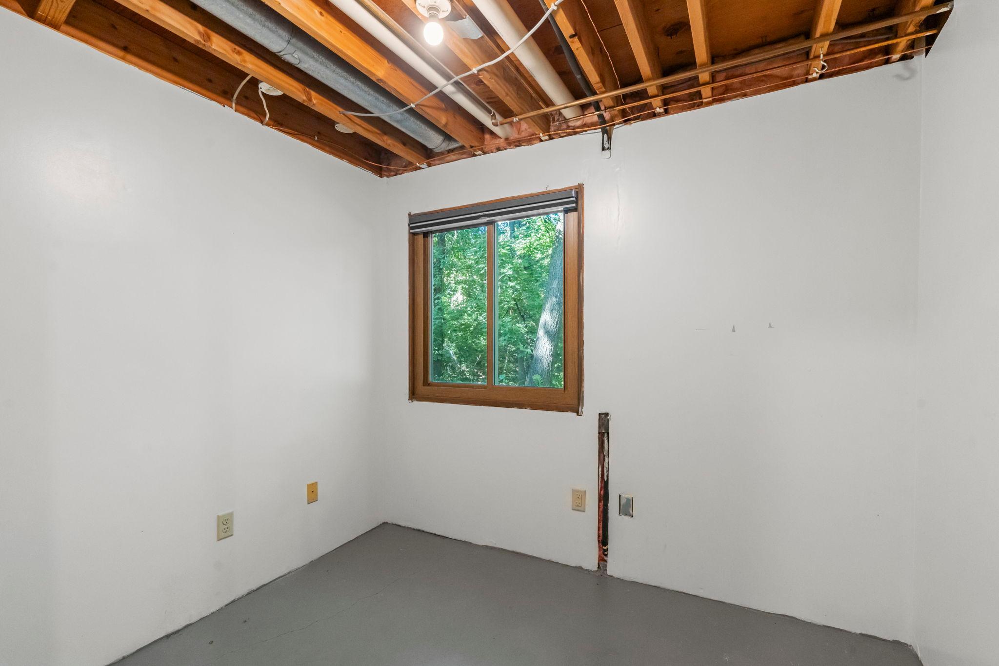 Partially finished lower level room looking out over the back yard.