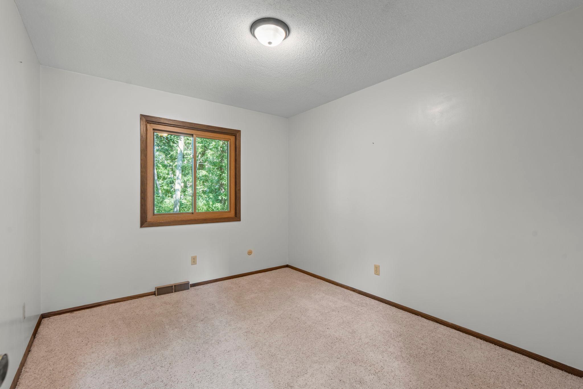 Second bedroom on the main level overlooking the backyard.