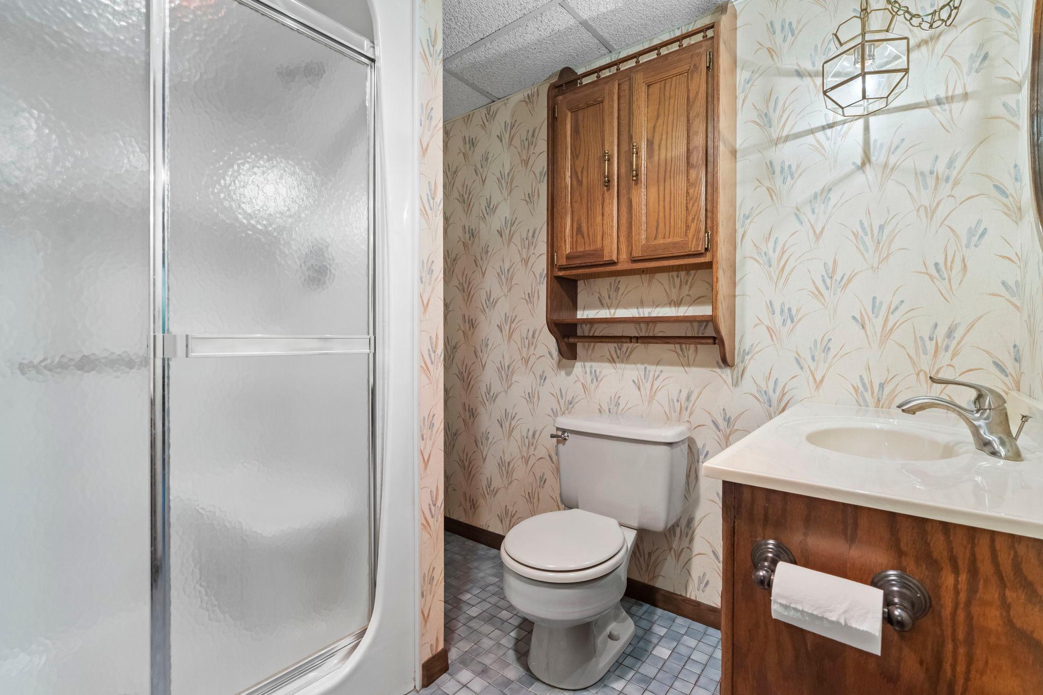 Walk in shower with unique tile flooring.