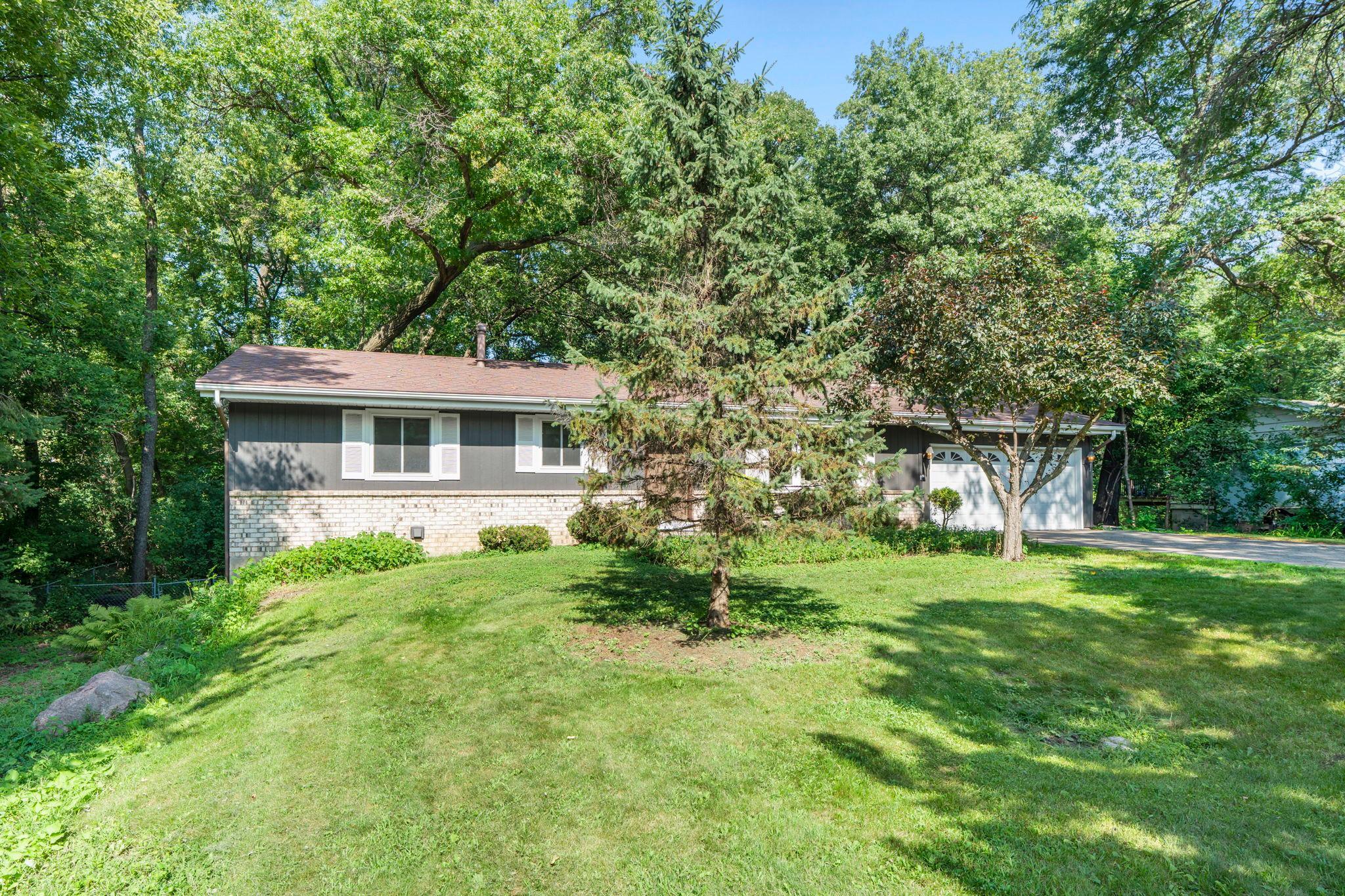 Open spacious front yard with wooded privacy.