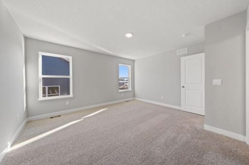 An oasis of its own, the primary suite offers the perfect escape. There's immediate access to a private bathroom. Photo is of similar home. Colors and options may vary. Ask Sales Agent for details.