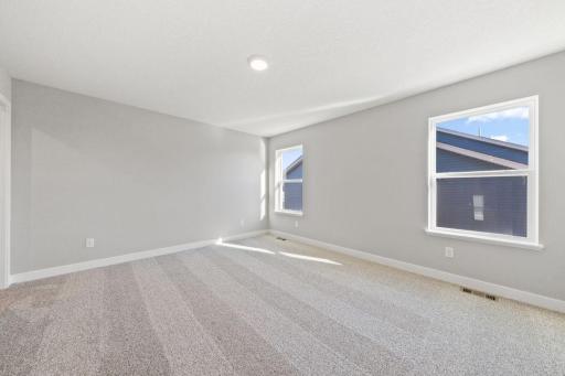 Owner's suite with bathroom en-suite. Photo is of similar home. Colors and options may vary. Ask Sales Agent for details.