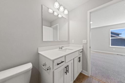 In addition to the space provided in the primary bedroom, the attached bath provides a true oasis to come home to, featuring a raised vanity and stand-in shower. Photo is of similar home. Colors and options may vary. Ask Sales Agent for details.