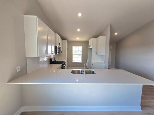 The Rushmore Kitchen shown with White cabinets at Highlands at Eagle View in Elko New Market. Photo is of actual home. Options and colors may vary. Ask Sales Agent for details.