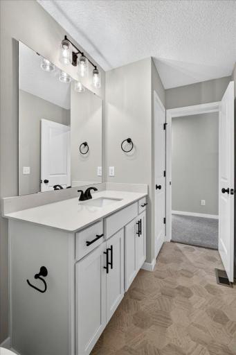 PHOTO OF A DIFFERENT HOME WITH SIMILAR PLAN AND FINISHES. Upper Full Bathroom features a Vanity with Soft Close Doors and Drawers, Quartz Countertop, and a Linen Closet for added storage.