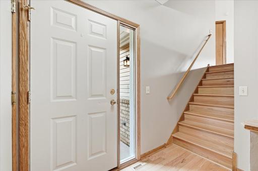 Inviting Entry w/hardwood flooring w/stairs to upper/lower levels, closet and door to garage