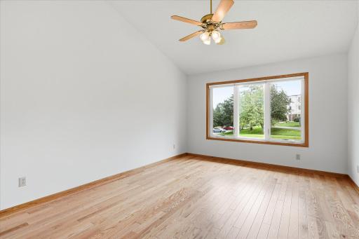 Upper level spacious Primary Bedroom Suite features vaulted ceiling, hardwood floors and ceiling fan/light