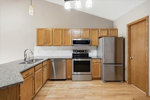 Remodeled Kitchen includes granite counter tops, undermount ss sink, white tile backsplash, ss appliances, breakfast bar counter w/pendant light and huge walk-in pantry