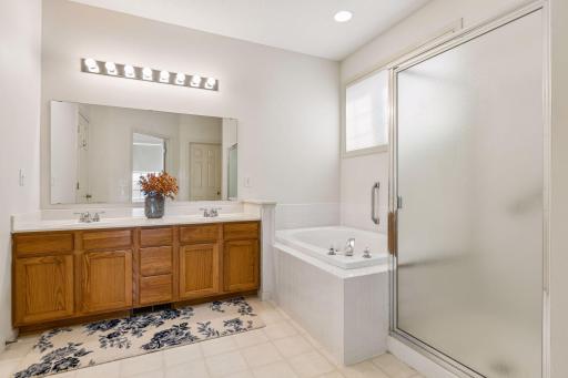 Huge primary bathroom with double vanity, separate tub, and shower.