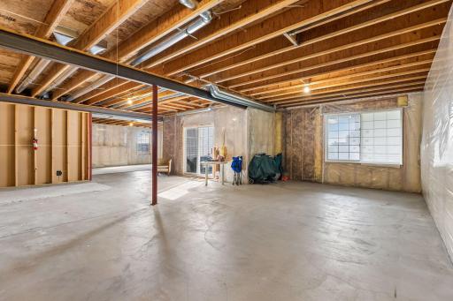 Natural light and patio access make this unfinished basement a promising future gathering space.