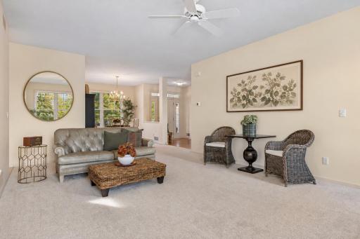 An open living room with space for multiple seating areas. Artwork and mirror virtually added.