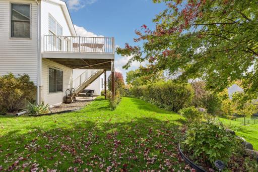 Backyard lawn space bordered by mature trees and established plantings.