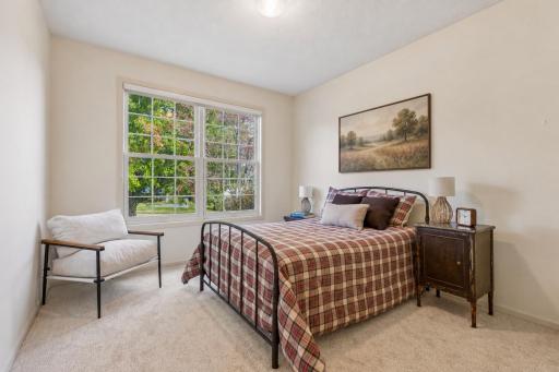 Second main-level bedroom with large window. Wall artwork virtually added.