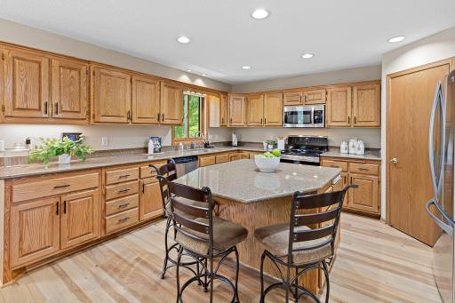 The kitchen offers a walk-in pantry, abundant cabinetry, granite counters and a center island.